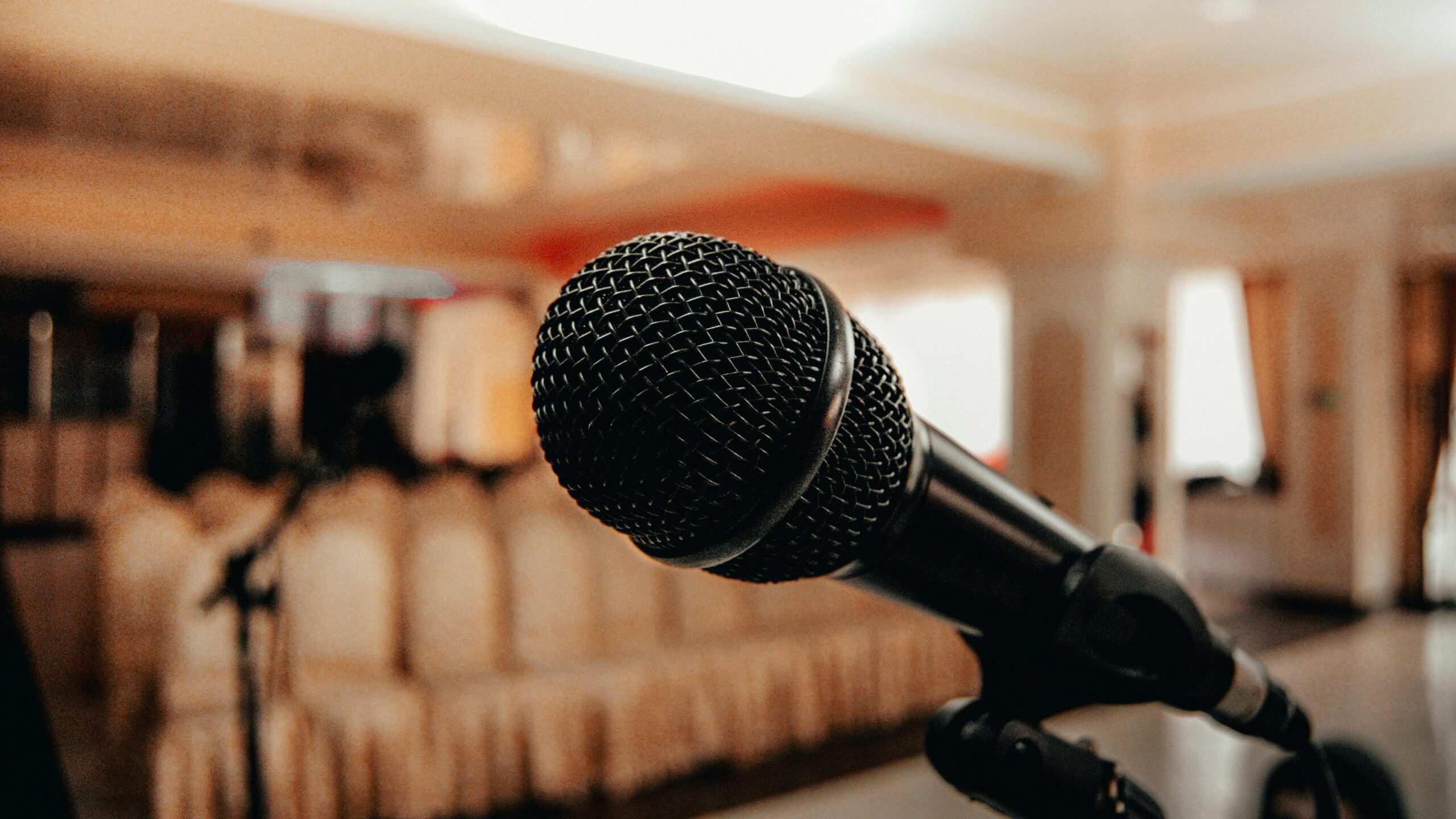 An image with a black mirophone in the foreground and an audience of chairs in the background. Image for Major PR blog post by Matt Maychak about speechwriting. Image by Borta sourced from Pexels.com.